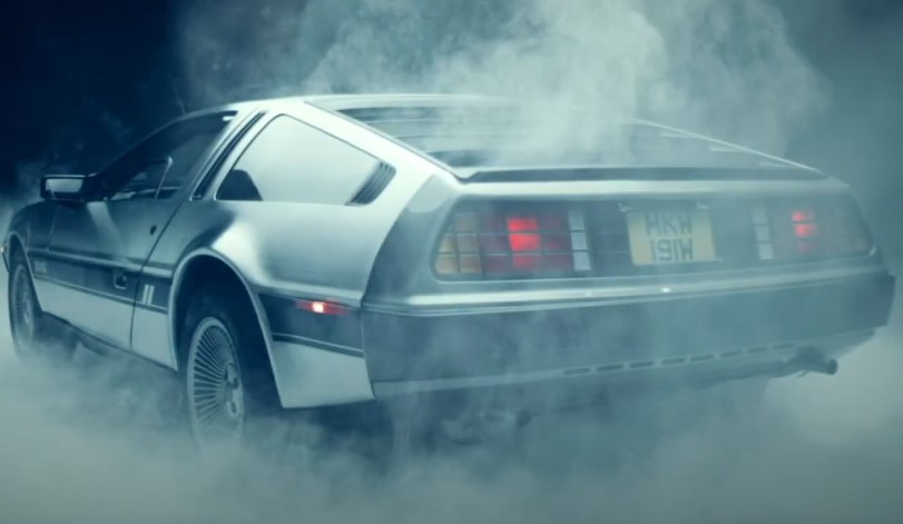 A sleek, silver DeLorean, bathed in a misty atmosphere