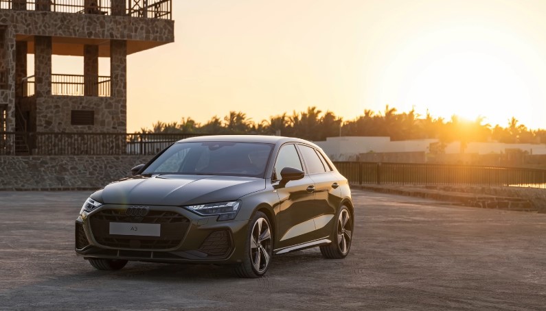 Dark green Audi A3 Hatchback parked outdoors at sunset