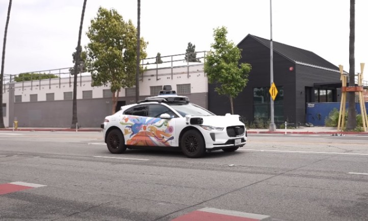 A self-driving car navigates down a city street