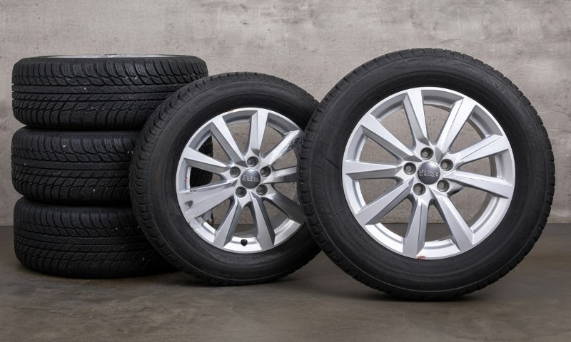 Four tires and a wheel arranged on a gray background