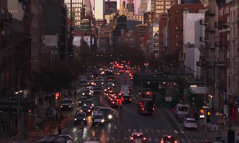 A busy city street filled with traffic, featuring tall buildings in the background