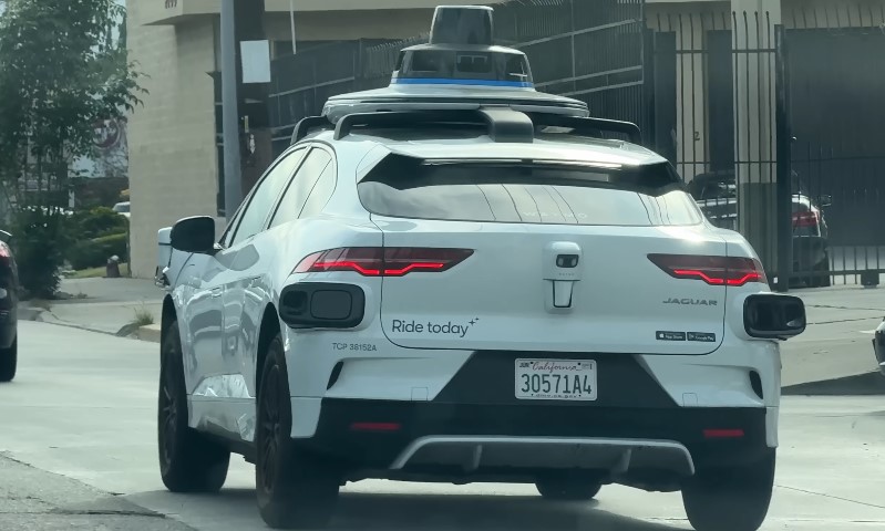 A self-driving car navigates down a city street