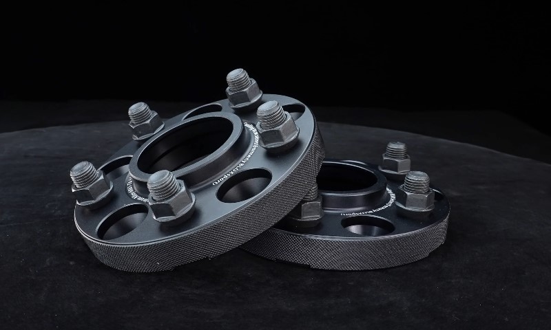 A pair of precision-machined wheel spacers with accompanying lug nuts