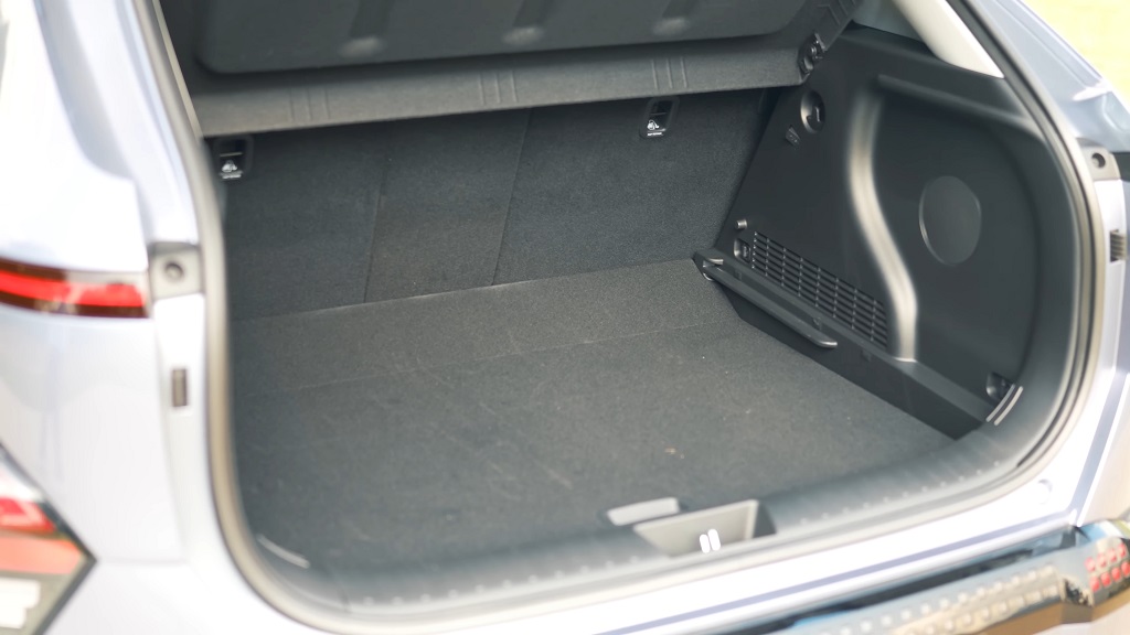 Open rear cargo area of an electric hatchback, showing a flat luggage floor and compact boot space designed for everyday practicality