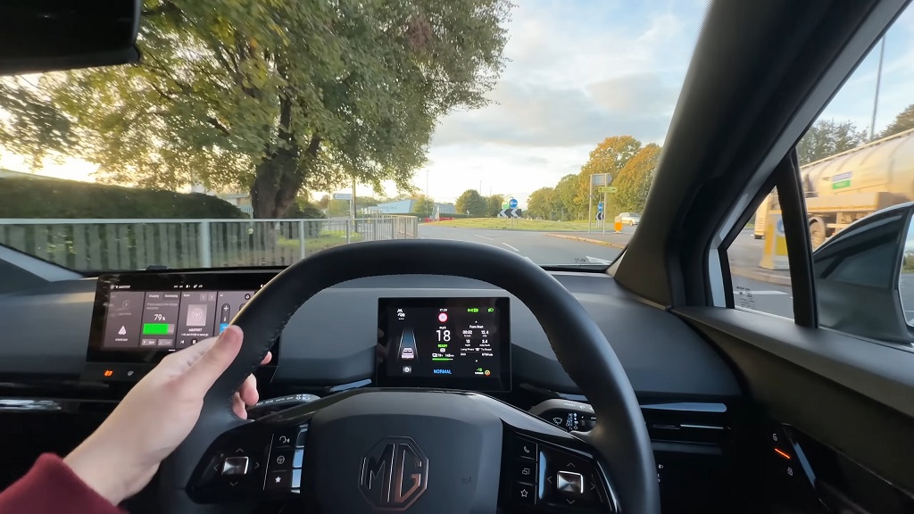 Driver’s view inside an electric hatchback, showing the steering wheel, digital instrument display, and road ahead during everyday driving