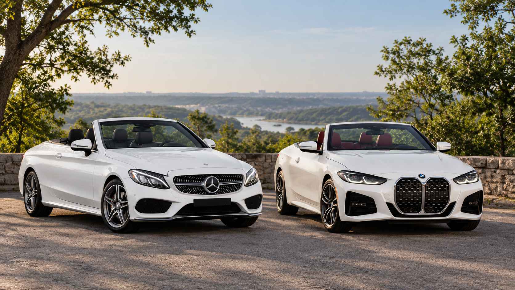 White Mercedes C300 and BMW 430i convertibles parked side by side with open roofs.