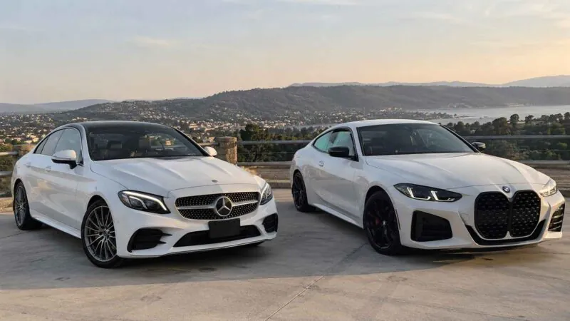 White Mercedes C300 and BMW 430i parked beside each other.