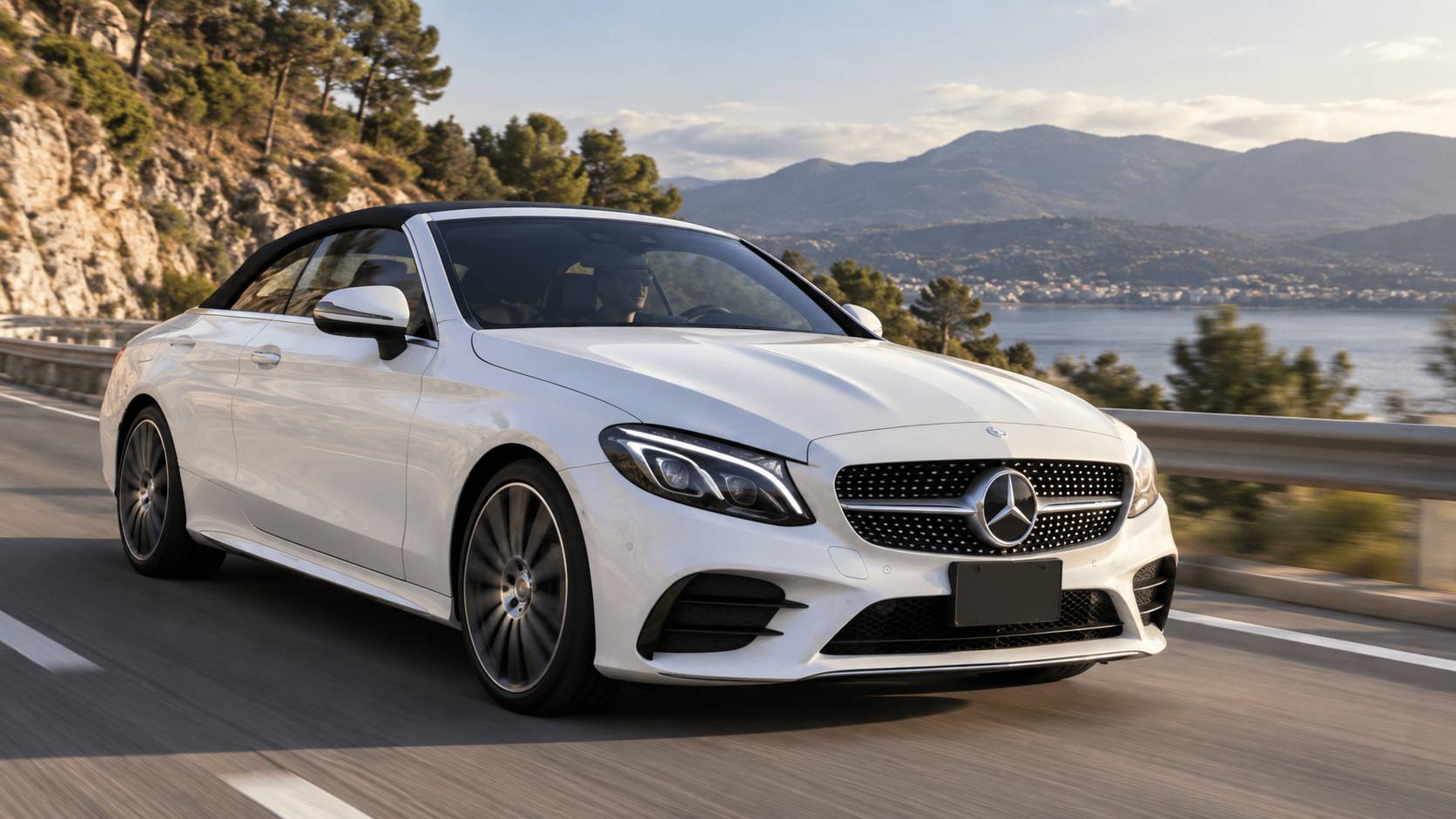 White Mercedes C300 Cabriolet driving beside the coast.